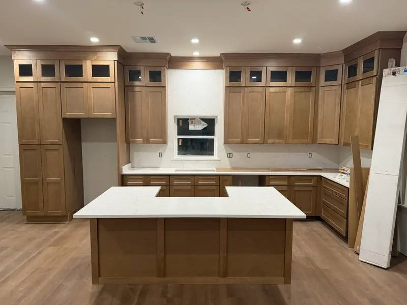Kitchen with double-stacked wood cabinets and a quartz island
