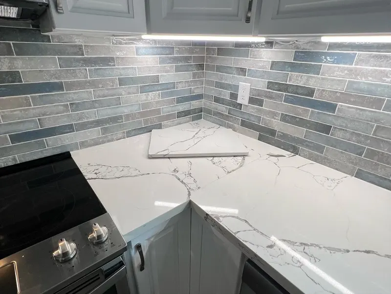 Kitchen with quartz counters and a tile backsplash