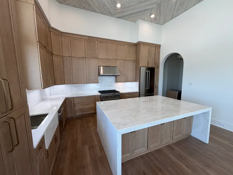 White kitchen with a waterfall peninsula