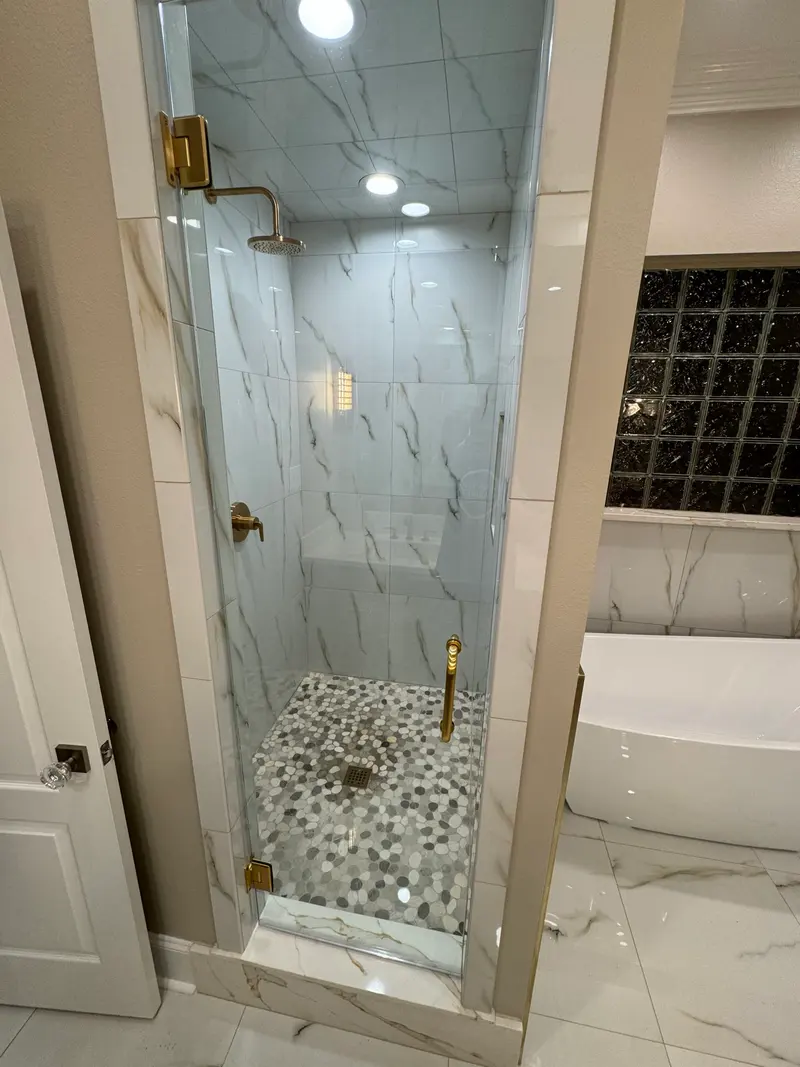 Glass shower with a pebble mosaic floor
